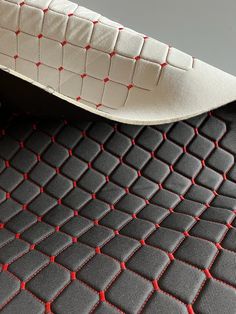 a close up view of a mattress with red stitching on the bottom and sides