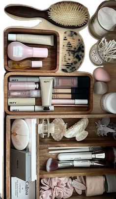 an open wooden drawer containing cosmetics and other personal care items, including toothbrushes