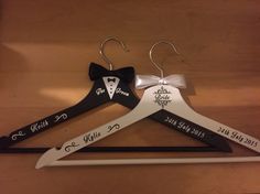 three wedding hangers with the names of their bride and grooms ties on them