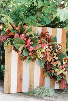 a wooden box with flowers and greenery on it