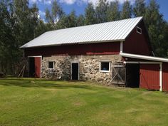 a red barn sitting on top of a lush green field