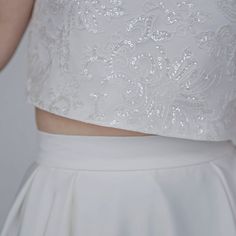 "The elegant and classy \"Aiko\" crop top features sparkly sequined lace mounted onto a matte ivory bridal satin, and it has wide fit cap sleeves, open triangle back and clear buttons. It is only available in shown ivory color. We recommend wearing backless bra with this top. Pair this top with any or our bridal bottoms: https://www.etsy.com/shop/WardrobeByDulcinea?ref=l2-shop-info-name%C2%A7ion_id&section_id=19306135 We would be needing these measurements from you and here are the instructi Glamorous White Cropped Top, Glamorous White Crop Top For Evening, Glamorous White Evening Crop Top, Elegant Sleeveless Lace Crop Top, Elegant Sleeveless Crop Top For Wedding, Elegant Sleeveless Crop Top With Lace, Elegant Crop Top With Boned Bodice, Elegant Wedding Tops With Boned Bodice, Cropped Lace Top For Party