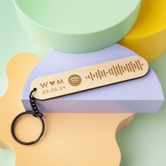 a wooden keychain with the word mom on it sitting next to other items