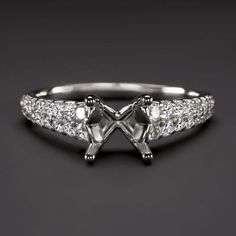 a white gold and diamond ring with two small diamonds on the band, set in 18k white gold