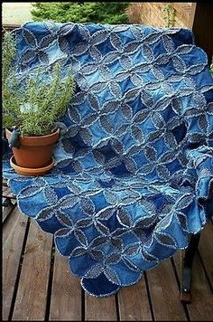 a potted plant sitting on top of a wooden table next to a blue blanket