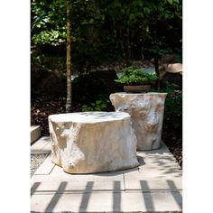 two cement planters sitting on top of a stone walkway