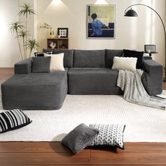 a living room filled with lots of furniture next to a white rug on top of a hard wood floor