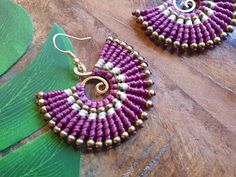 Gorgeous purple macramé earrings; a perfect burst of colour for the boho queen in you. These wire wrapped earrings feature a golden wire spiral, purple macramé waxed cotton and golden brass beads. For pierced ears, these boho earrings have been lovingly handmade from nickel-free brass wire and skillfully woven waxed cotton which is strong and water-proof. Please do swipe through all the product pictures to get a comprehensive view of the colour and hang of the earrings. Please read the below, in Bohemian Handwoven Brass Earrings, Purple Hippie Jewelry For Gifts, Purple Hippie Jewelry For Gift, Bohemian Handwoven Brass Jewelry, Hippie Style Purple Jewelry For Gift, Handwoven Brass Earrings For Gift, Bohemian Spiral Adjustable Earrings, Adjustable Spiral Bohemian Earrings, Unique Gold Macrame Jewelry