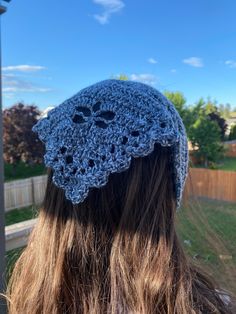 the back of a woman's head wearing a blue crocheted beanie