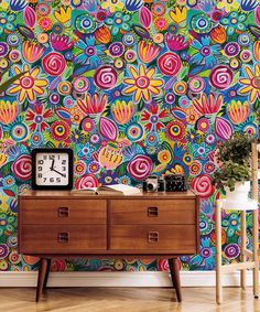 a colorful wallpapered room with a clock and dresser in front of the table