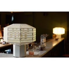 a table lamp sitting on top of a counter next to a glass filled with liquid