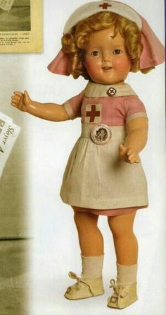 the doll is wearing a nurse's outfit and has her hands up in the air