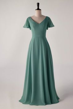 a green dress on a mannequin dummy with the back turned to look like it is