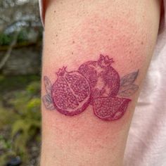 a pomegranate tattoo on the left arm