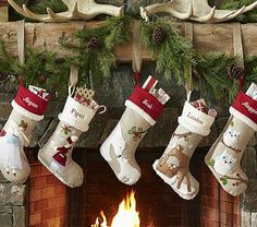 christmas stockings hanging from the fireplace in front of a fire place