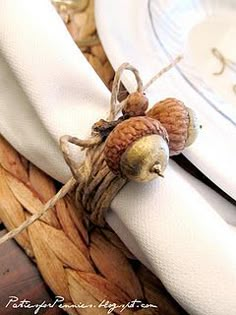 two acorns sitting on top of a white napkin next to a fork and knife