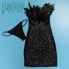 a black dress with feathers on it and a face mask next to it that says univok