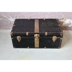 an old black suitcase is sitting on the floor