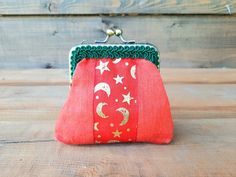 a red purse with stars and moon on it sitting on top of a wooden table