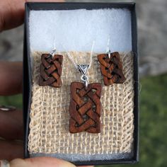 "This beautiful and unique hand-carved wooden Celtic knot jewelry set will be made for you, or a loved one, in my studio on the West of Ireland. These dainty rosewood Celtic necklace & earrings are recycled from musical instruments constructed by a local luthier. As a musician myself, I take enormous satisfaction in creating a jewelry set whose inherent wood has previously featured in a beautiful hand-made guitar. Also, part of rosewood's attractiveness is its durability and ability to stand Artisan Wooden Jewelry As A Gift, Artisan Wood Jewelry Gift, Rustic Wooden Beads Jewelry As A Gift, Handmade Mahogany Jewelry For Gift, Handmade Mahogany Jewelry Gift, Handmade Artisan Wood Jewelry, Mahogany Wooden Beads Jewelry, Rustic Jewelry With Wooden Beads For Gifts, Mahogany Handmade Jewelry For Gift