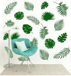 a green chair sitting in front of a white wall with palm leaf decals on it