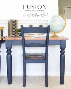 a desk with two chairs and a globe on top of it in front of a white wall