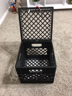 a black crate sitting on top of a carpeted floor