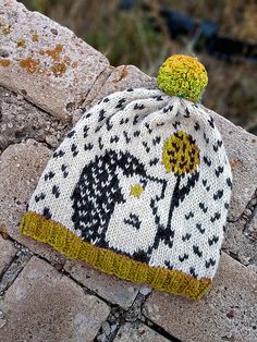 a knitted hat sitting on top of a stone wall