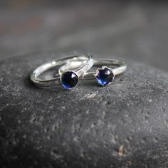 Do you need a gift for someone with a September birthday or to celebrate your 5th wedding anniversary? This sterling silver synthetic sapphire stacking ring is perfect if your birthstone is sapphire or you need a simple navy blue ring. Here are the details:This ring is made with either a rose cut (faceted) or smooth 5mm synthetic sapphire cabochon set in a sterling silver bezel and on a sturdy band handmade in your size. It can be worn with other stackable rings, or by itself.Please select your Stackable Sapphire Rings For Gifts, Stackable Sapphire Rings As Gift, Dainty Stackable Sapphire Ring For Anniversary, Classic Sapphire Birthstone Ring Gift, Adjustable Sapphire Ring With Birthstone, Stackable Sapphire Ring Gift, Blue Sapphire Stackable Birthstone Ring, Sapphire Stackable Rings With Bezel Setting For Anniversary, Dainty Blue Sapphire Stackable Ring