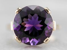 This amethyst cocktail ring is bold and beautiful! Set into a high profile, this amethyst is a deep royal purple, flashing with hues of violet and raspberry. The simple gold mounting puts the gem on full display, creating an instant showstopper! Metal: 14K Yellow Gold Gem: Amethyst 8.41 Carats Gem Measurements: 14 mm, Round Ring Size: 7.75 Marks: "14K" Stamped on the inside band Classic Purple Amethyst Ring Round Cut, Classic Purple Amethyst Ring With Round Cut, Classic Purple Amethyst Round Cut Ring, Formal Purple Amethyst Ring With Round Stone, Timeless Purple Amethyst Ring, Formal Purple Amethyst Solitaire Ring, Formal Purple Solitaire Amethyst Ring, Formal Round Purple Amethyst Ring, Timeless Purple Amethyst Ring For Formal Occasions