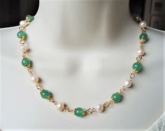 This classic beaded necklace features beautiful 10mm green jade gemstones and ivory freshwater pearls. Necklace is finished with a lobster closure. The necklace measures 16 inches in length, with 2 inches extension. This simple yet elegant pair of earrings features 10mm green jade gemstone drop with a tiny freshwater pearl. Hanging from a surgical steel lever-back, it measures 1.25 " in length. Earrings are light weight and sway gracefully as you move about your day. This beautiful necklace is u Jade Choker Necklace, Pearl And Jade Necklace, Jade Pearl Necklace, Elegant Green Jade Pearl Necklace, Elegant Jade Beaded Necklace With 8mm Beads, Elegant Jade Pearl Necklace For Gift, Green Pearl Necklace, Jade Necklaces, Green Jade Necklace