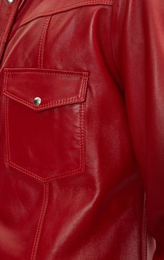 a woman wearing a red leather jacket with buttons on the front and side pockets, close up