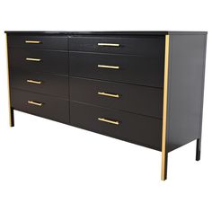 a black dresser with gold handles and drawers