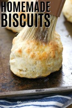 an image of homemade biscuits being smothered with butter on a baking sheet and text overlay that reads, how to make homemade biscuits