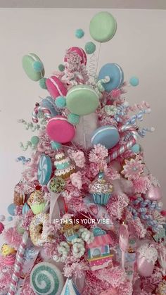 a pink christmas tree decorated with balloons and sweets