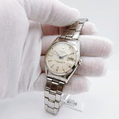 Men's Rolex 34mm Date Vintage Stainless Steel Watch with Cream Dial and Smooth Bezel. Pre-Owned SN# 485**** Year: 1976. Brand: Rolex. Crystal: Plastic. Gender: Men's. Case Back: Solid. Dial Color: Silver Dial. Condition: Very Good. Model Number: 6534. Case Dimensions: 34mm. Metal Type: Stainless Steel. Bezel Color: Stainless Steel. Model: Oyster Perpetual Date. Bracelet / Strap: Stainless Steel. Movement: Mechanical (Automatic). Box / Certificate: Rolex Box / Certificate of Authenticity. Service Warranty: One (1) Year Limited Service Warranty. Classic Analog Diamond Watch, Classic Round Diamond Analog Watch, Classic Diamond Watch With Date Indicator, Classic Round Dial Jewelry And Watches For Anniversary, Classic Watch Bands For Anniversary, Classic Diamond Watch With Chronometer And Rectangular Dial, Classic Diamond Watch With Rectangular Dial And Chronometer, Classic Watch Accessories With Rectangular Dial And Date Display, Vintage White Gold Business Watches