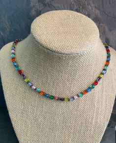 This colorful glass choker has vivid colors including red, blue, orange, green, pink and purple. This multicolored choker is made with vivid colors that add  a special pop to almost all your clothing choices. Yhe small square beads are called myuki and are made in Japan.  This choker would be an exceptional accessory to add to your jewelry collection. 18" long Multicolor Beaded Crystal Glass Necklaces, Adjustable Multicolor Single Strand Beaded Necklace, Multicolor Glass Beaded Crystal Necklaces, Multicolor Glass Beaded Crystal Necklace, Multicolor Glass Crystal Necklace With Colorful Beads, Multicolor Beaded Crystal Necklace For Party, Adjustable Multicolor Single Strand Jewelry, Vibrant Rainbow Jewelry With Colorful Design, Adjustable Rainbow Glass Necklaces