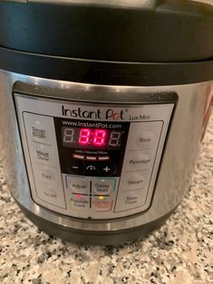 an instant pot is sitting on the counter top with its digital clock displayed in front of it