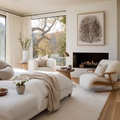 a bedroom with white furniture and a fireplace in the corner next to a large window