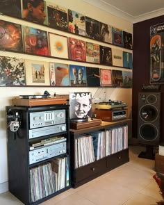 there are many records on the wall in this room with speakers and stereos around it