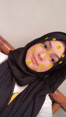 a woman with yellow smiley faces on her face