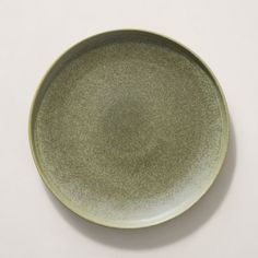 a green plate sitting on top of a white table