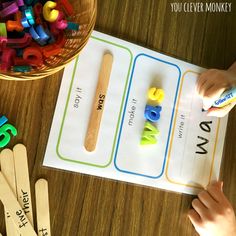 two children are playing with letters and numbers on a table next to some wooden spoons