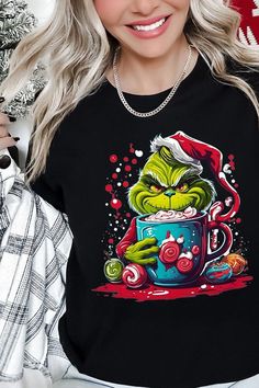 Indulge in the festive fun with this 'Giggling Grinch' unisex graphic tee! This merry piece is perfect for celebrating Grinchmas, showcasing a vibrant graphic of the iconic character enjoying a hot holiday treat. Made from high-quality materials, this tee promises warmth and softness for the chilly holiday season. This unisex tee, originating from Nicaragua, provides a comfortable fit for all, making it an excellent choice for holiday gifting or for bringing some playful vibes to your wardrobe. Snap Jewelry Charms, Christmas Pjs Family, Winter Family, Christmas Pjs, Plus Swimwear, Grinch Christmas, Girls Boutique, Graphic Tops, Holiday Shirts