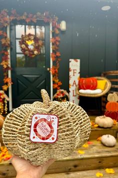 a hand holding up a woven pumpkin