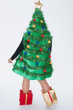 Get into the holiday spirit with this scuba knit mini dress in the shape of a Christmas tree, featuring a tiered tinsel design, multicolor pom pom accents, dropped armholes, opening for the face with a star on top, and two presents with openings for the legs. | 100% polyester | Hand wash cold | Model is 5'8" and wearing a Size 1X | Christmas Tree Dress Christmas Tree Dress, Plus Size Christmas, Tree Dress, Scuba Knit, Knit Mini Dress, Ugly Sweater, Holiday Spirit, The Holiday, The Face