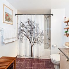 a bathroom with a tree shower curtain next to a toilet