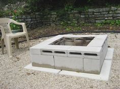 a cement fire pit sitting on top of a gravel field