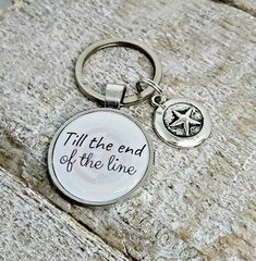 a metal keychain with the words till the end of the line on it