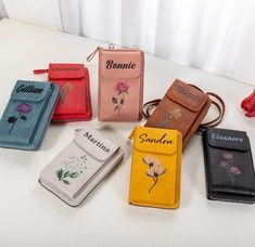 five different colored purses sitting on top of a white table next to each other